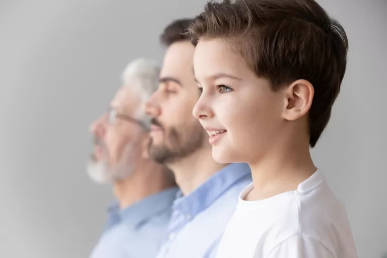 Drei Generationen an Männer in einer Reihe aufgestellt.