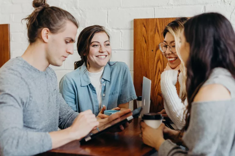 Vier Kollegen beim Kaffee trinken und arbeiten