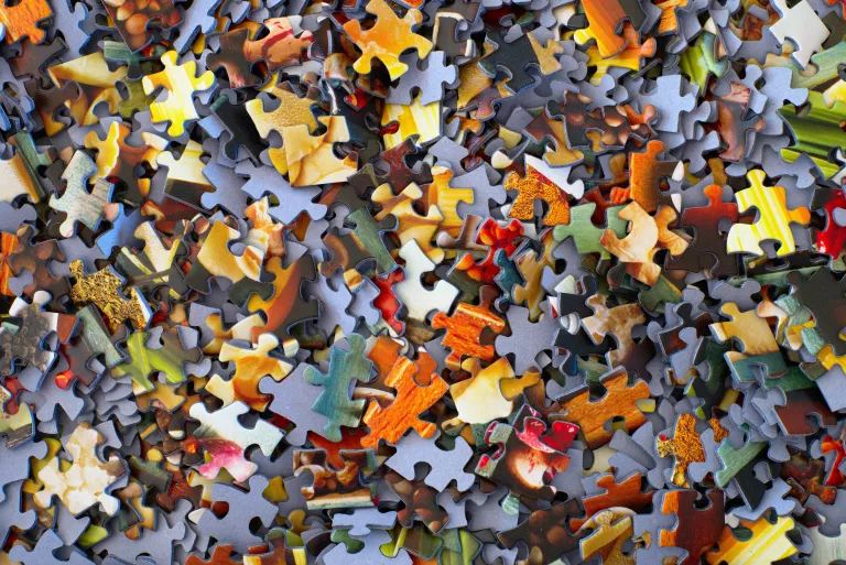 Viele bunte Puzzlteile auf einem Haufen