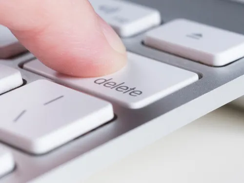 Finger drückt auf die Lösch-Taste einer Laptoptastatur 